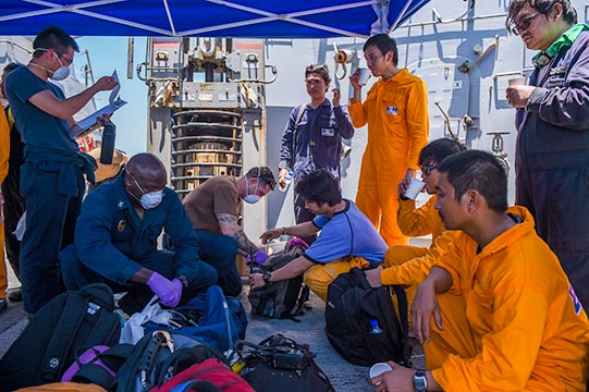 Sailors aboard USS Bainbridge (DDG-96) render aid to the crew of the M/V Kokuka Courageous on June 13, 2019 in the Gulf of Oman. US Navy Photo